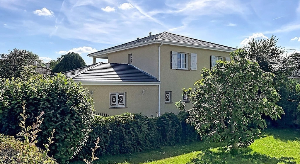 Maison moderne entièrement rénovée avec façade propre et toiture neuve en tuiles sombres anthracite